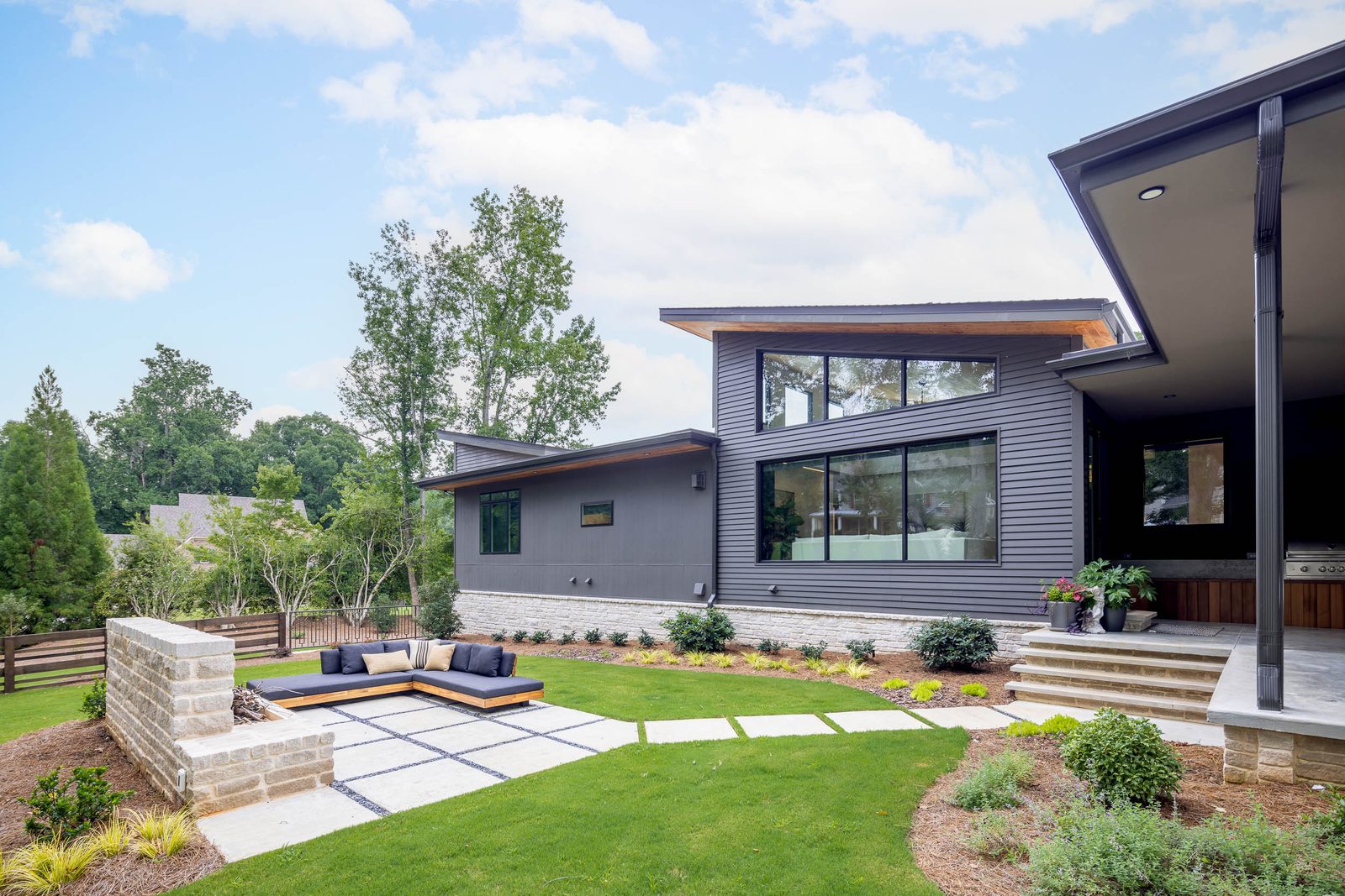 Rear patio with stone seat wall and sunken lounge — The Ortiz Home, custom home built by Ironwood Construction Group in Sugar Hill, Georgia