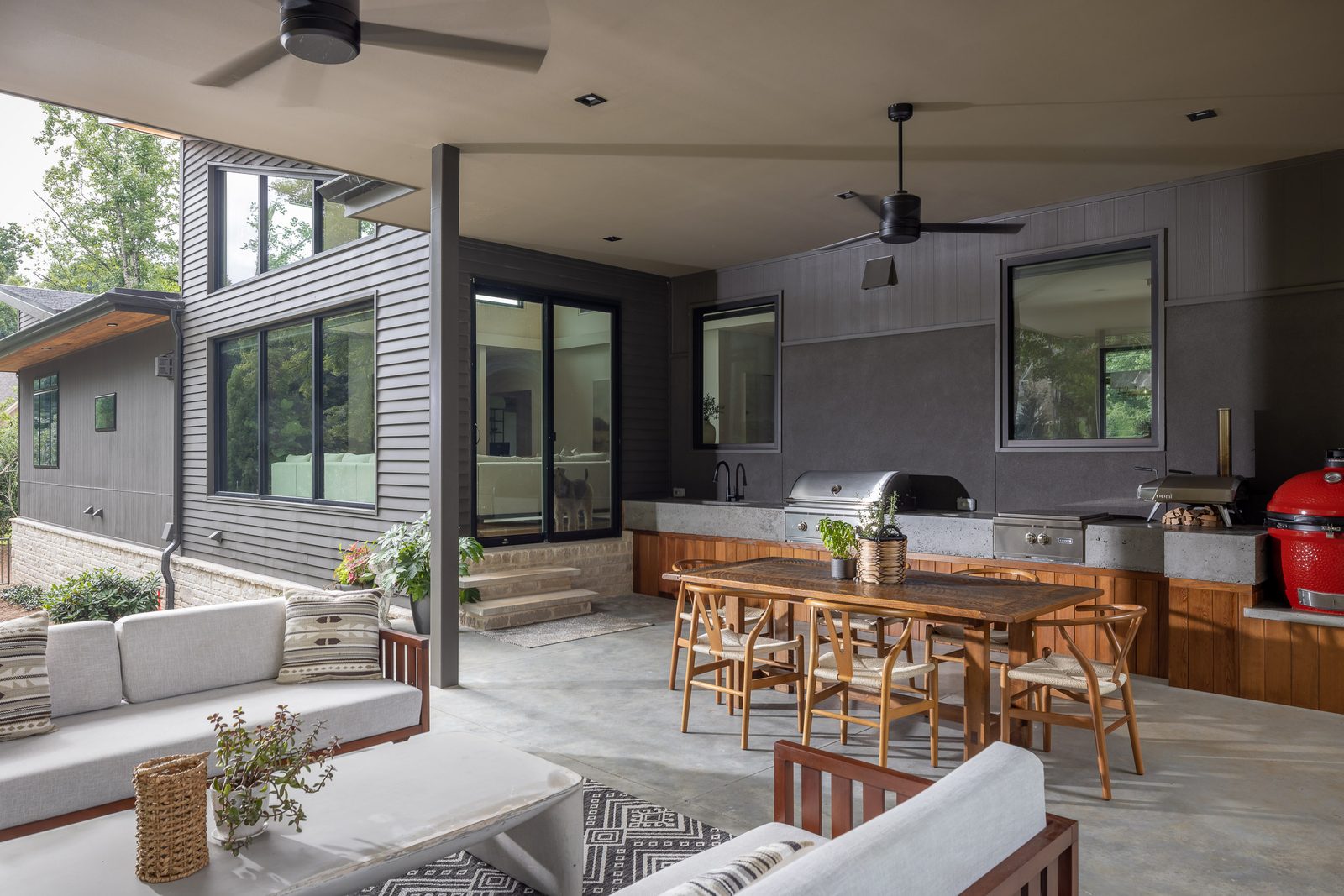 Covered patio outdoor kitchen with grill and bar seating — The Ortiz Home, custom home built by Ironwood Construction Group in Sugar Hill, Georgia