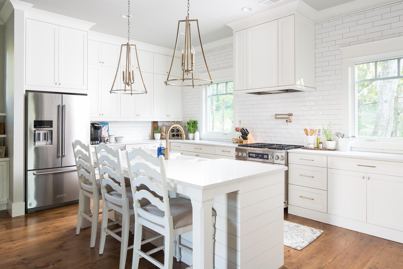 Kitchen island with apron-front sink and bar stools — Austin Garner Rd, custom home built by Ironwood Construction Group