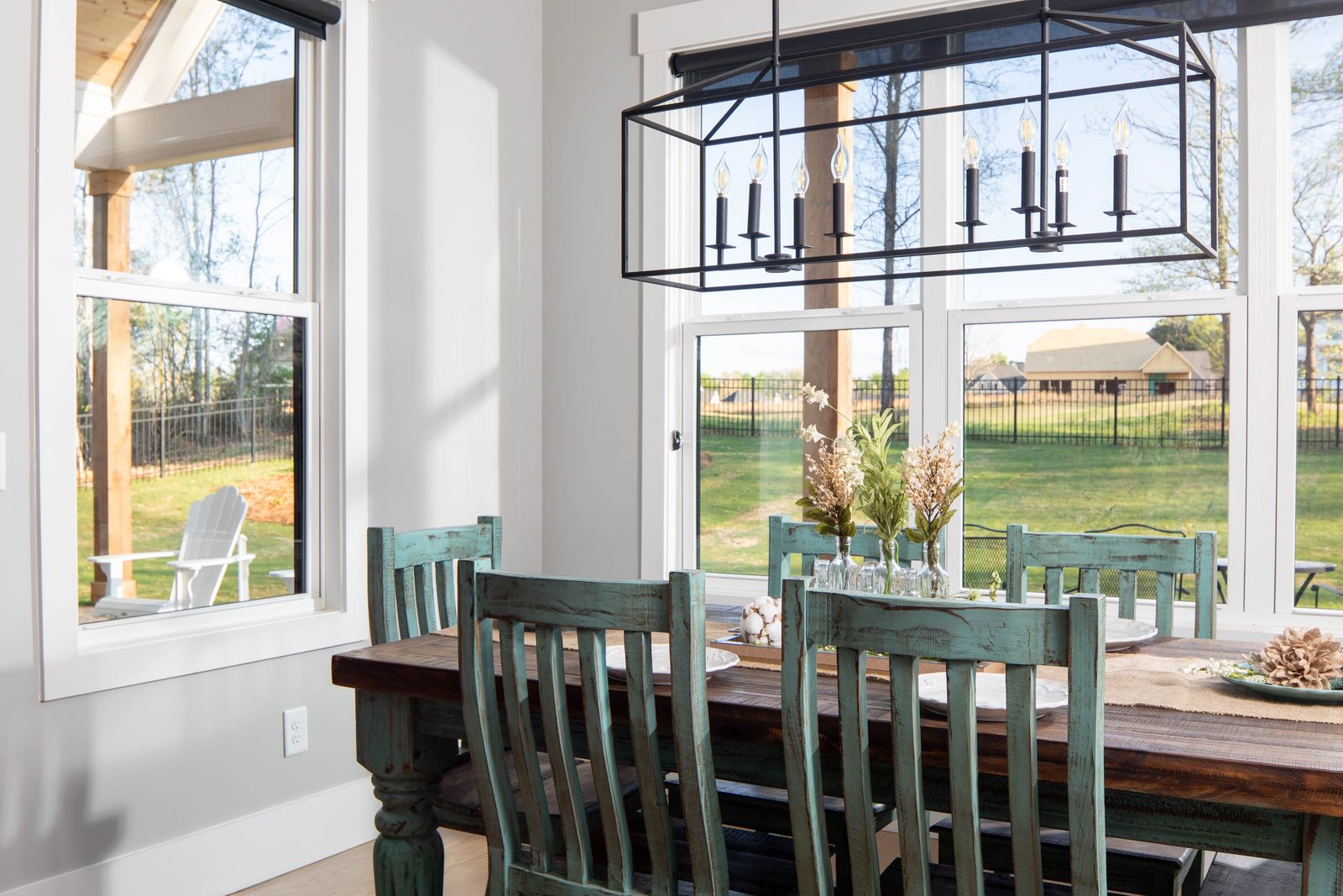 Breakfast area with green chairs and lantern lighting — Glausier, custom home built by Ironwood Construction Group