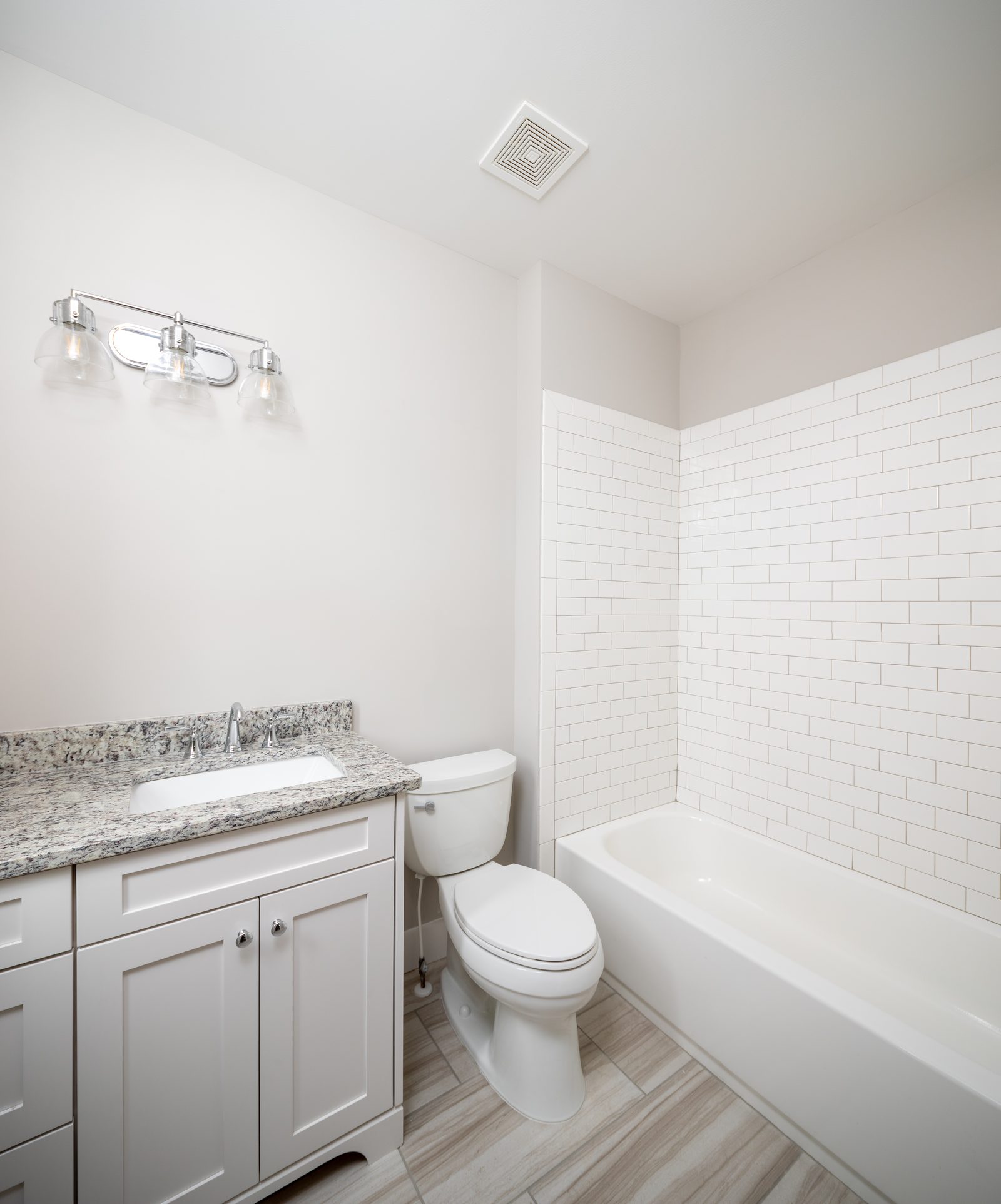 Secondary bath with granite vanity and tiled tub surround — Shadburn Ferry, custom home built by Ironwood Construction Group in Buford, Georgia