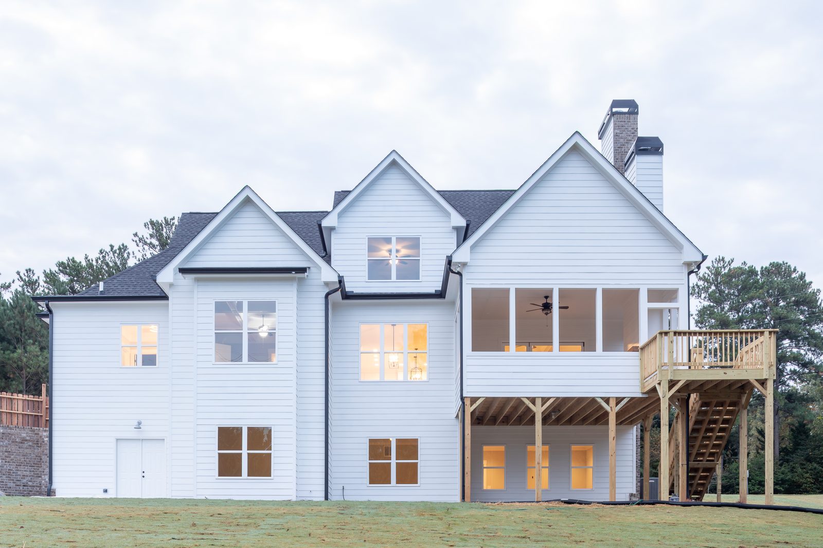 Rear elevation with screened porch and deck stair — Shadburn Ferry, custom home built by Ironwood Construction Group in Buford, Georgia